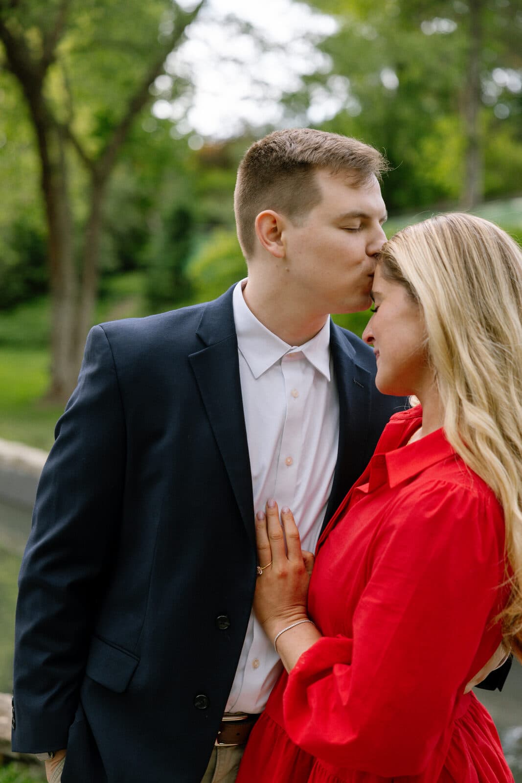 Trenton kissing Sydney on the forehead, her hand resting on his chest.