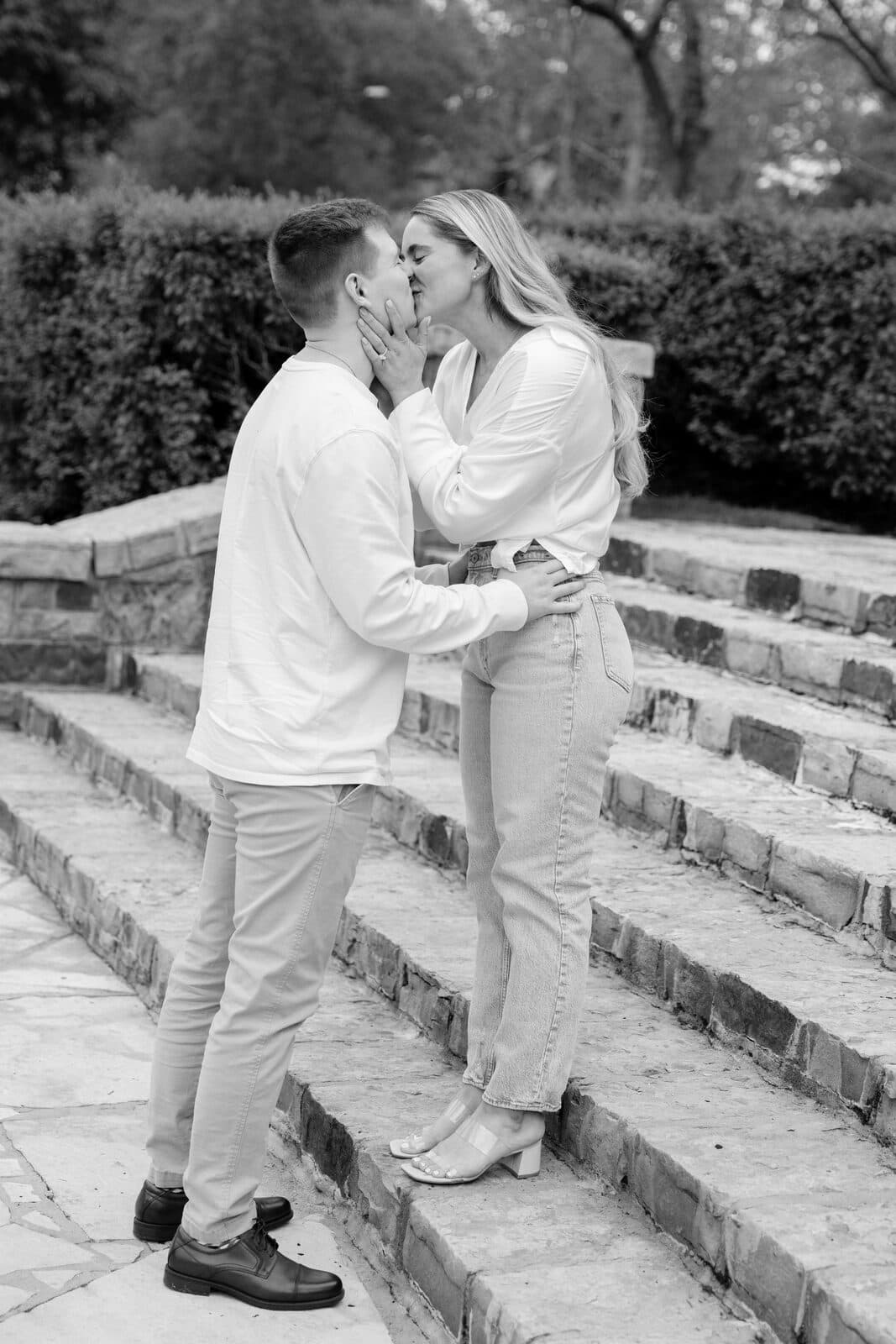Sydney and Trenton sharing a kiss on the stone steps.
