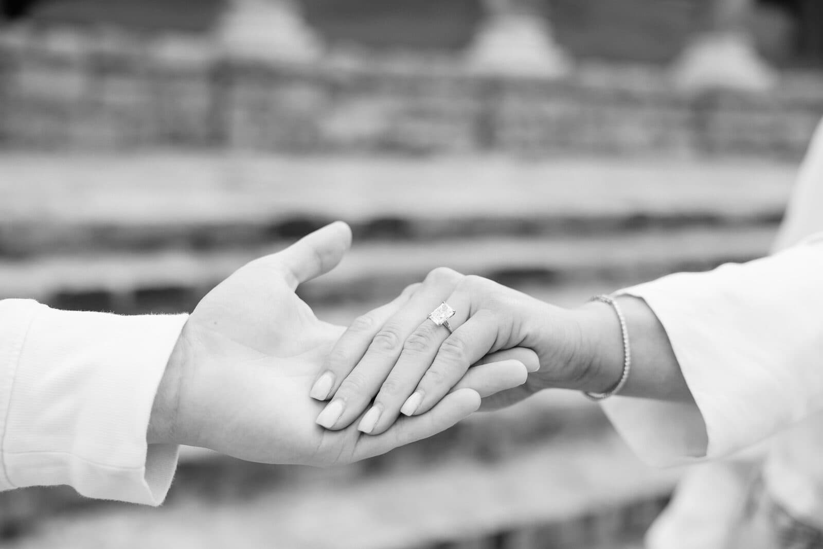 A close view of Sydney's engagement ring as they hold hands.